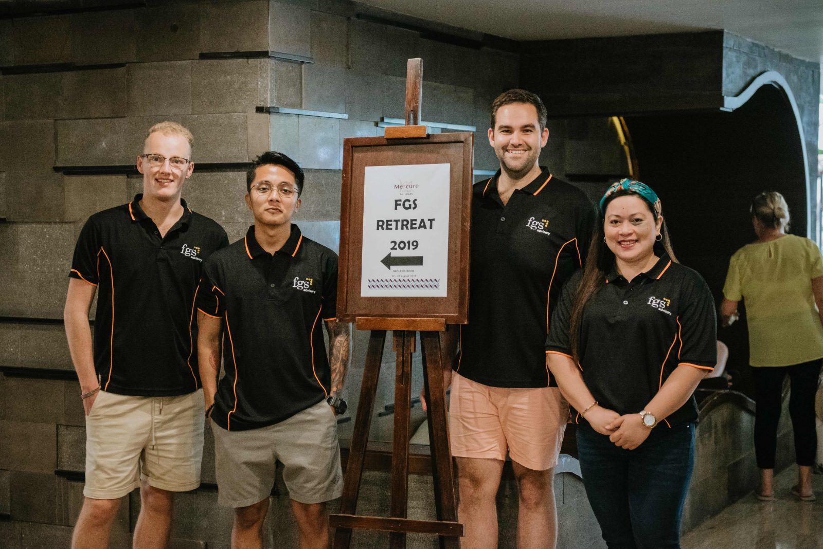 Team members beside an FGS retreat sign